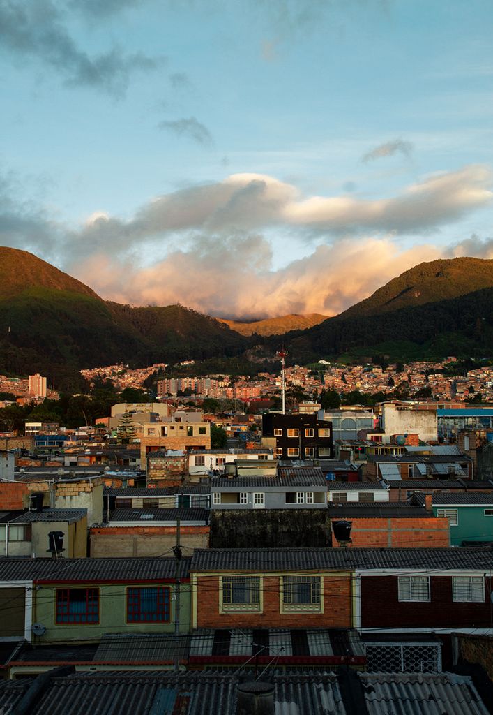 Breathtaking Bogotá cityscape with mountains at sunset, showcasing urban and natural beauty.