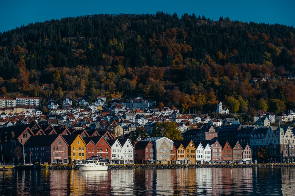 Charming view of Bergen's colorful waterfront houses with autumn foliage in the background.