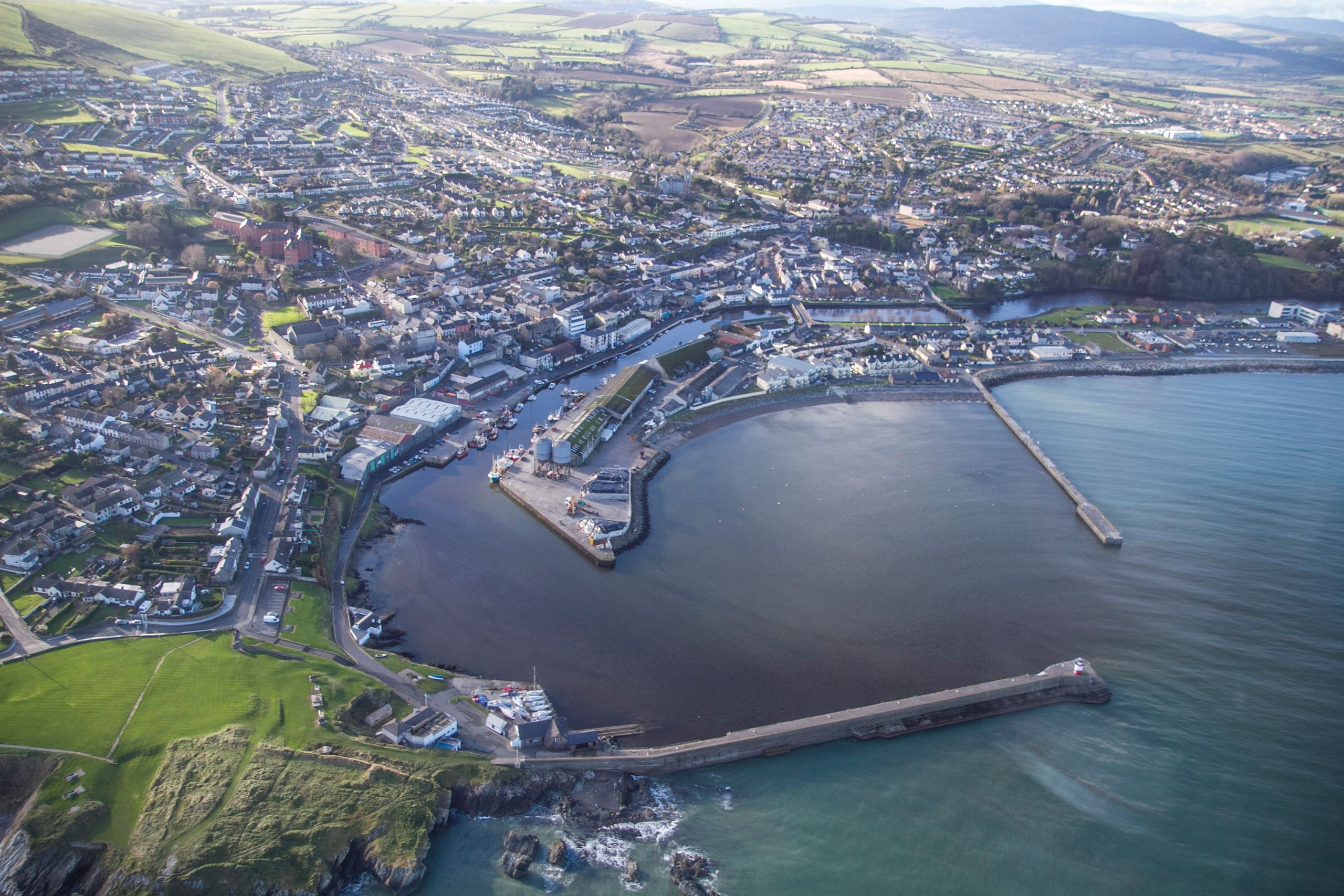 A stunning aerial view captures Wicklow's coastal town and harbor, showcasing the scenic coastline.