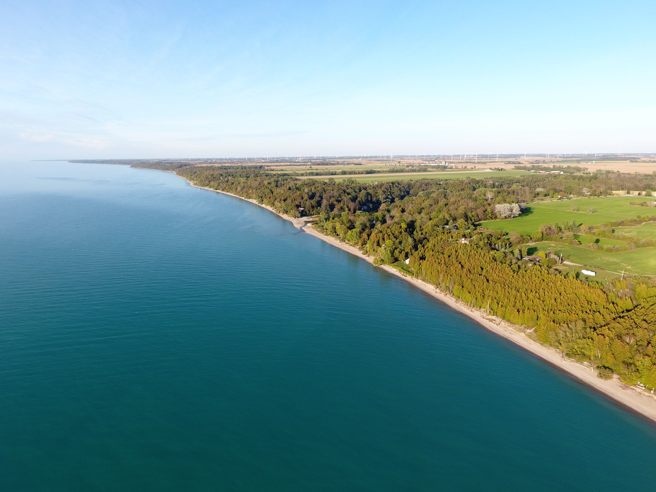 A breathtaking aerial shot of a coastline with lush greenery and clear blue waters.