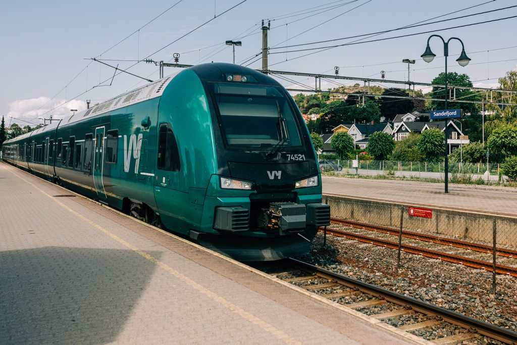 A modern passenger train at Sandefjord station in Norway. Urban transportation captured on a sunny day.